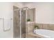 Modern bathroom featuring a tiled walk-in shower, soaking tub, and neutral color scheme at 20828 Cattail Blvd, Venice, FL 34292