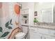 Bathroom with colorful shower curtain, granite countertop, white cabinetry, and decorative plants at 20828 Cattail Blvd, Venice, FL 34292