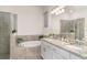 Bathroom featuring a soaking tub, walk-in shower, dual sinks, granite counters, and white cabinetry at 20828 Cattail Blvd, Venice, FL 34292