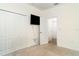 Bright bedroom featuring carpet floors, a wall-mounted TV, and a closet with white bi-fold doors at 20828 Cattail Blvd, Venice, FL 34292
