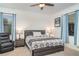 Bedroom with a ceiling fan, king-size bed, two windows, and a black recliner at 20828 Cattail Blvd, Venice, FL 34292