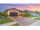 Single-story home featuring a tile roof, paved driveway, and well-maintained landscaping with stone accents at 20828 Cattail Blvd, Venice, FL 34292