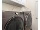 Laundry room with front loading washer and dryer with white cabinets and wire shelving at 20828 Cattail Blvd, Venice, FL 34292