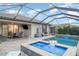 Screened-in lanai with a pool, spa, outdoor dining, and outdoor kitchen at 20828 Cattail Blvd, Venice, FL 34292