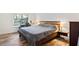Bedroom with rustic wooden bed frame, wood-look tile flooring, and natural light at 2095 Sunset Point Rd # 2201, Clearwater, FL 33765