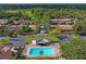 Aerial view of a community pool featuring a cabana, lounge chairs, and a palm tree at 2095 Sunset Point Rd # 2201, Clearwater, FL 33765
