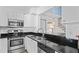 Modern kitchen features stainless steel appliances, sleek black countertops, and white cabinetry at 2095 Sunset Point Rd # 2201, Clearwater, FL 33765