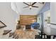 Open-concept living area with wood accent wall, high ceilings, and staircase access to upper level at 2095 Sunset Point Rd # 2201, Clearwater, FL 33765