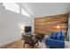 Inviting living room featuring a wood accent wall, high ceilings, and ample natural light at 2095 Sunset Point Rd # 2201, Clearwater, FL 33765