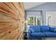 Living room featuring a wood accent wall, natural light, and access to the outdoor patio at 2095 Sunset Point Rd # 2201, Clearwater, FL 33765