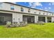 Home's backyard featuring lush lawn, decorative bushes, AC units, and private screened patios at 2513 Sunray Venus Way, Ruskin, FL 33570