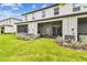 Home's backyard featuring lush lawn, bushes, AC units, and private screened patios at 2513 Sunray Venus Way, Ruskin, FL 33570