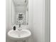 Well-lit bathroom with a modern pedestal sink and minimalist decor at 2513 Sunray Venus Way, Ruskin, FL 33570