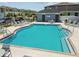 Community pool with sun loungers, ample seating, and a nearby bath house at 2513 Sunray Venus Way, Ruskin, FL 33570