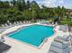 Beautiful community pool surrounded by sun loungers, tables, and lush greenery at 2513 Sunray Venus Way, Ruskin, FL 33570