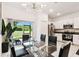 Open concept dining area with a glass table adjacent to a modern kitchen and stainless steel appliances at 2513 Sunray Venus Way, Ruskin, FL 33570