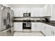 Modern kitchen with stainless steel appliances, white cabinetry, and dark countertops for a sleek design at 2513 Sunray Venus Way, Ruskin, FL 33570