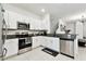 Contemporary kitchen featuring white cabinets, granite countertops, stainless steel appliances, and modern tile flooring at 2513 Sunray Venus Way, Ruskin, FL 33570