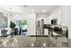 Bright kitchen showcasing granite countertops, stainless steel appliances, and an adjacent dining area with outdoor access at 2513 Sunray Venus Way, Ruskin, FL 33570