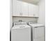 Bright laundry room features a washer, dryer, and ample storage at 2513 Sunray Venus Way, Ruskin, FL 33570