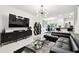 Open concept living room with modern décor featuring white tile flooring and an elegant chandelier at 2513 Sunray Venus Way, Ruskin, FL 33570