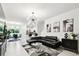 Open concept living room with modern décor featuring white tile flooring and an elegant chandelier at 2513 Sunray Venus Way, Ruskin, FL 33570