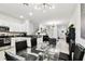 Spacious, open living space featuring modern lighting, glass table, and sleek kitchen appliances at 2513 Sunray Venus Way, Ruskin, FL 33570