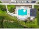 Aerial view of a community pool with lounge chairs, tables, and lush landscaping at 2513 Sunray Venus Way, Ruskin, FL 33570