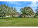Expansive backyard with mature trees and screened-in lanai, perfect for outdoor living and entertaining at 26616 Whirlaway Ter, Wesley Chapel, FL 33544