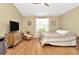 Comfortable bedroom featuring hardwood floors, a ceiling fan, and a sunlit window at 26616 Whirlaway Ter, Wesley Chapel, FL 33544