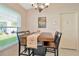 Inviting dining area featuring a wooden table, chandelier lighting, and large windows at 26616 Whirlaway Ter, Wesley Chapel, FL 33544