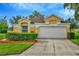 Charming single-story home with a well-maintained lawn, lush landscaping, and a two-car garage at 26616 Whirlaway Ter, Wesley Chapel, FL 33544