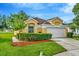 Inviting single-story home with a two-car garage, manicured lawn, and verdant shrubbery at 26616 Whirlaway Ter, Wesley Chapel, FL 33544