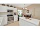 Well-lit kitchen with white cabinets, stainless steel appliances, and breakfast bar seating at 26616 Whirlaway Ter, Wesley Chapel, FL 33544
