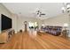 Spacious living room with hardwood floors, ceiling fan, and sliding glass doors to the outdoor patio at 26616 Whirlaway Ter, Wesley Chapel, FL 33544