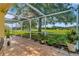 Outdoor patio area with tile flooring, a screened enclosure and a scenic view of the lawn at 26616 Whirlaway Ter, Wesley Chapel, FL 33544