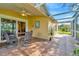 Covered patio with views of the landscaped lawn and a table with seating for outdoor dining at 26616 Whirlaway Ter, Wesley Chapel, FL 33544