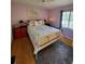 Bedroom with white iron bed, floral bedding and laminate flooring at 2685 Sabal Springs Cir # 202, Clearwater, FL 33761