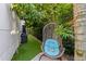 Cozy backyard nook featuring a hanging chair, artificial turf, and shaded by mature trees at 2711 W Trilby Ave, Tampa, FL 33611