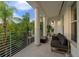 Spacious covered balcony with white columns offers outdoor seating and views of lush tropical landscaping at 2711 W Trilby Ave, Tampa, FL 33611