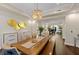 Chic dining room with statement lighting, wood floors, and a view into the grand living room at 2711 W Trilby Ave, Tampa, FL 33611