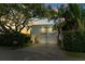 Modern two-story home features a clean facade, balconies, lush trees and a basketball hoop at 2711 W Trilby Ave, Tampa, FL 33611