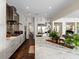 Open kitchen featuring white cabinets, marble countertops, stainless steel appliances, and an adjacent living area at 2711 W Trilby Ave, Tampa, FL 33611