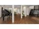 Open living area with a grand piano, decorative pillars, and hardwood flooring at 2711 W Trilby Ave, Tampa, FL 33611