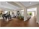 Bright open-concept living room featuring a grand piano, hardwood floors, and access to the outdoor patio at 2711 W Trilby Ave, Tampa, FL 33611