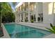 Gorgeous in-ground pool with an integrated spa, surrounded by tropical landscaping and a covered patio at 2711 W Trilby Ave, Tampa, FL 33611