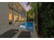 Backyard pool with columns, tropical plants, and lounge chairs offers a private outdoor retreat at 2711 W Trilby Ave, Tampa, FL 33611
