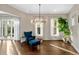 Cozy sitting room with a blue chair, ottoman, modern light fixture, and lots of natural light at 2711 W Trilby Ave, Tampa, FL 33611