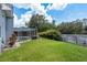 Expansive backyard featuring a screened pool area, lush lawn, and a private fenced perimeter at 2800 Resnik W Cir, Palm Harbor, FL 34683