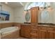 Bathroom features a double vanity with granite countertop, soaking tub, and beautiful lighting at 2800 Resnik W Cir, Palm Harbor, FL 34683